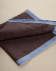 Dark brown clutch bag with light blue linen edge